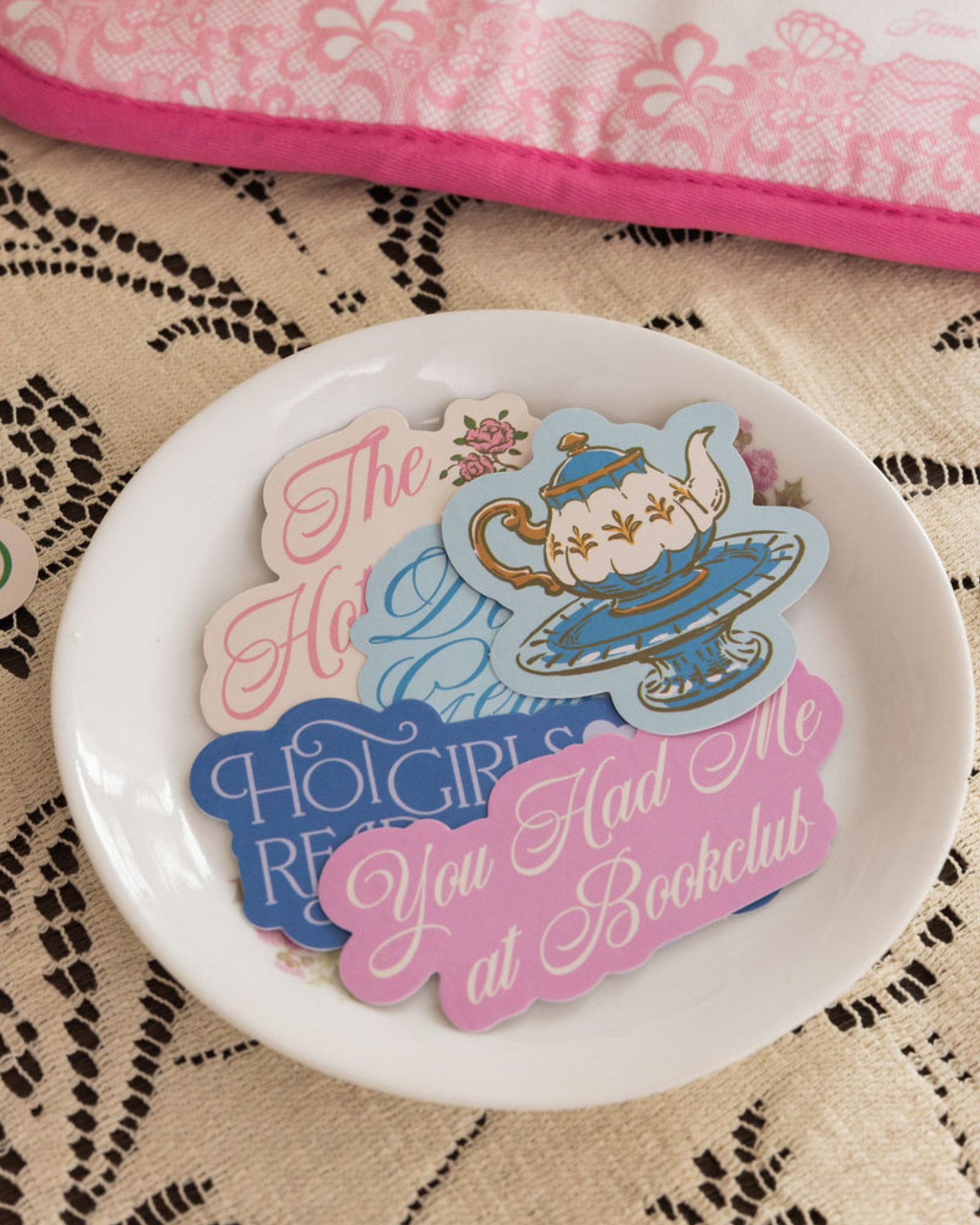 Decorative plate with colorful text and graphics on a lace tablecloth