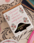 Tea bag holder with floral design and quote on a lace tablecloth
