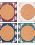 Four round coasters with floral decorative borders on a white background