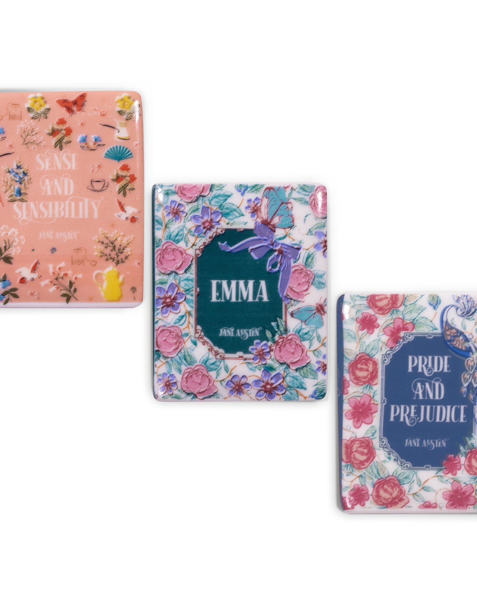 Three book-themed magnets with floral designs and book titles on a white background