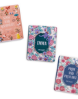 scattered Three book-themed magnets with floral designs and book titles on a white background