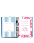Open planner with decorative cover and interior pages on a white background