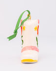 Decorative boot ornament with floral patterns and a green ribbon on a light gray background