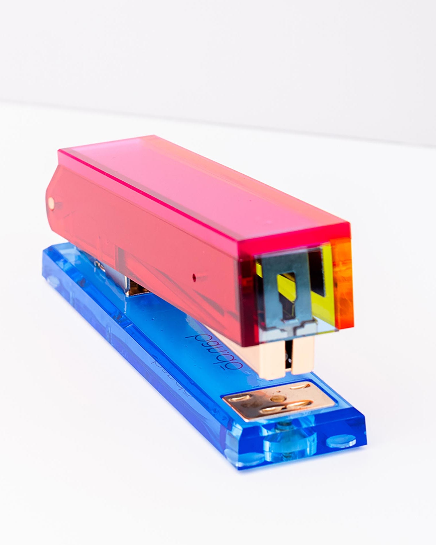 Colorful stapler with pink top and blue base on a white background