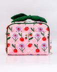 Pink quilted bag with floral and cherry pattern on a white background