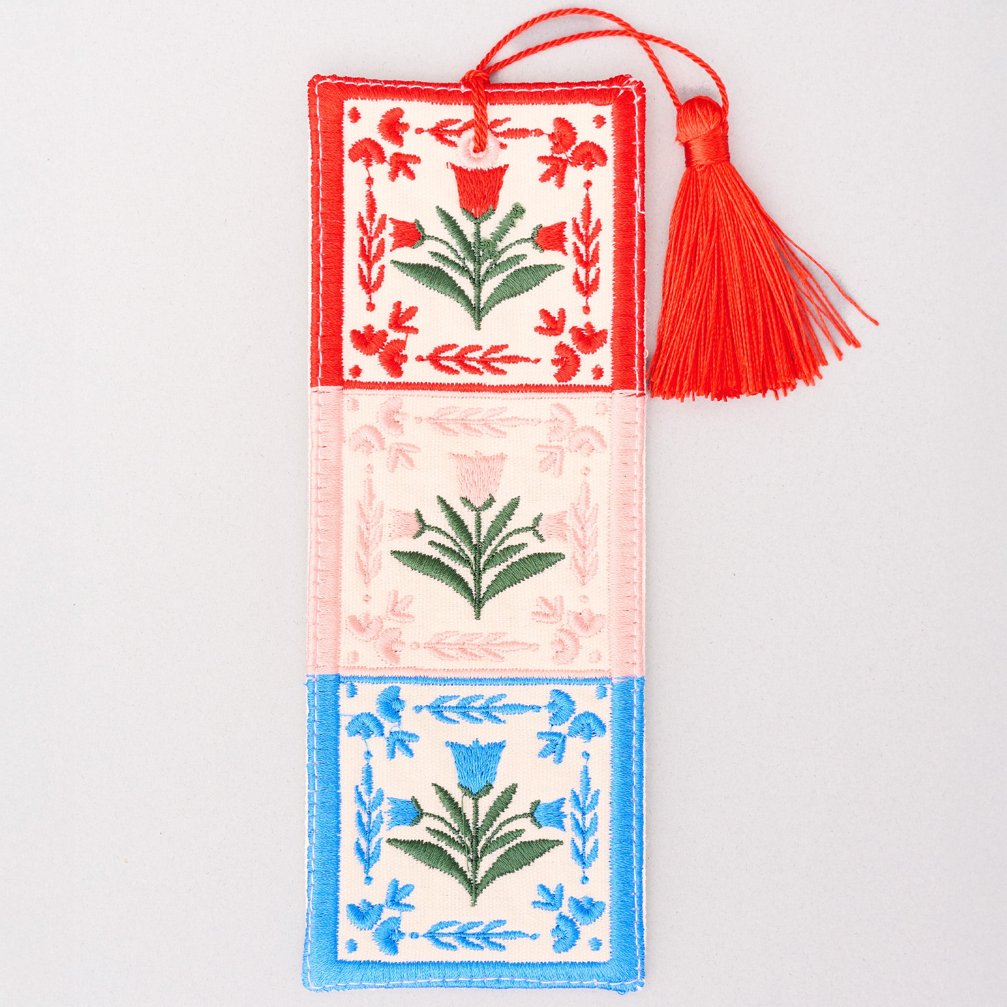Decorative bookmark with floral patterns and a red tassel on a light gray background