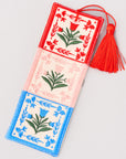 Decorative bookmark with floral patterns and a red tassel on a light gray background
