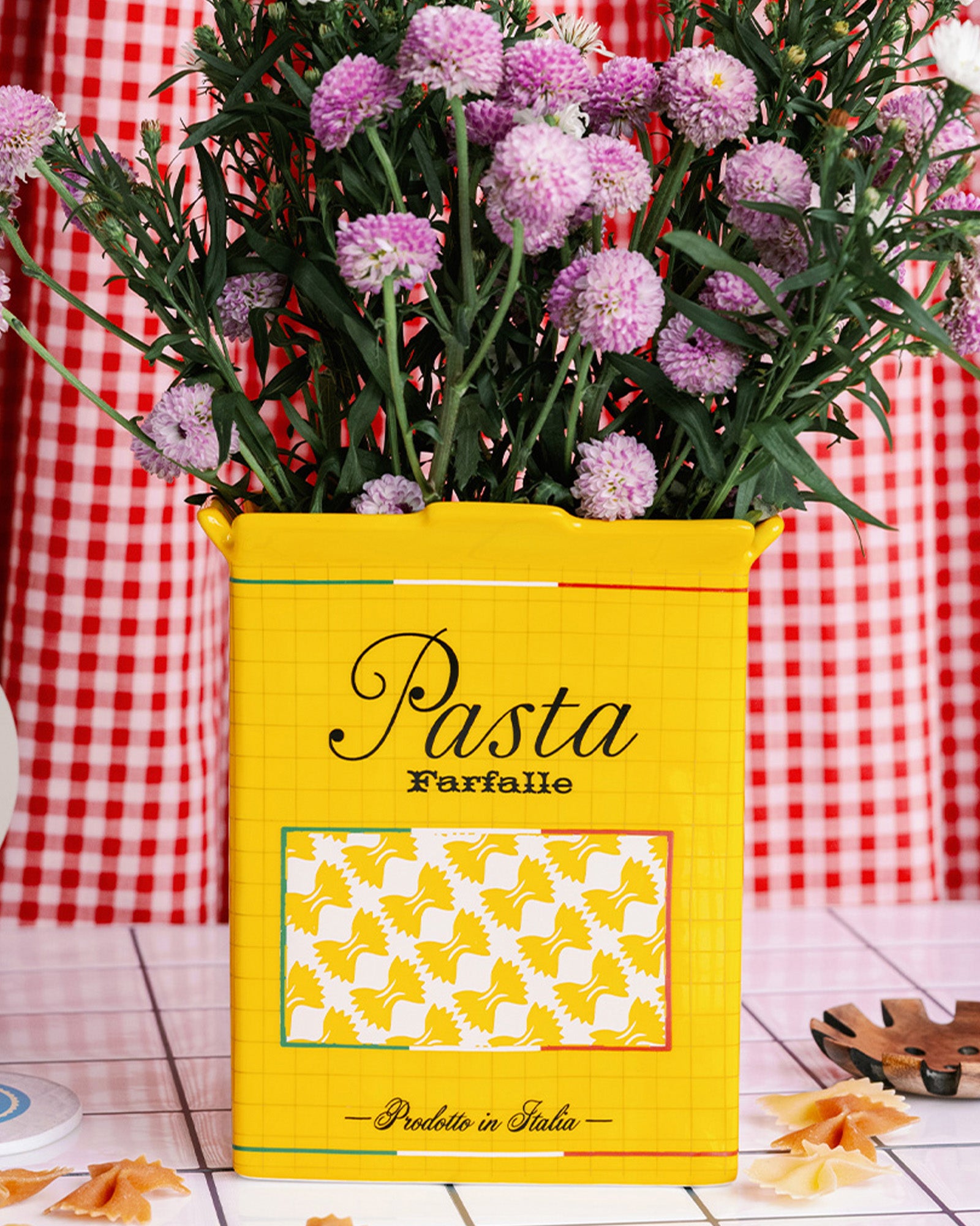 yellow pasta box vase with purple flowers inside