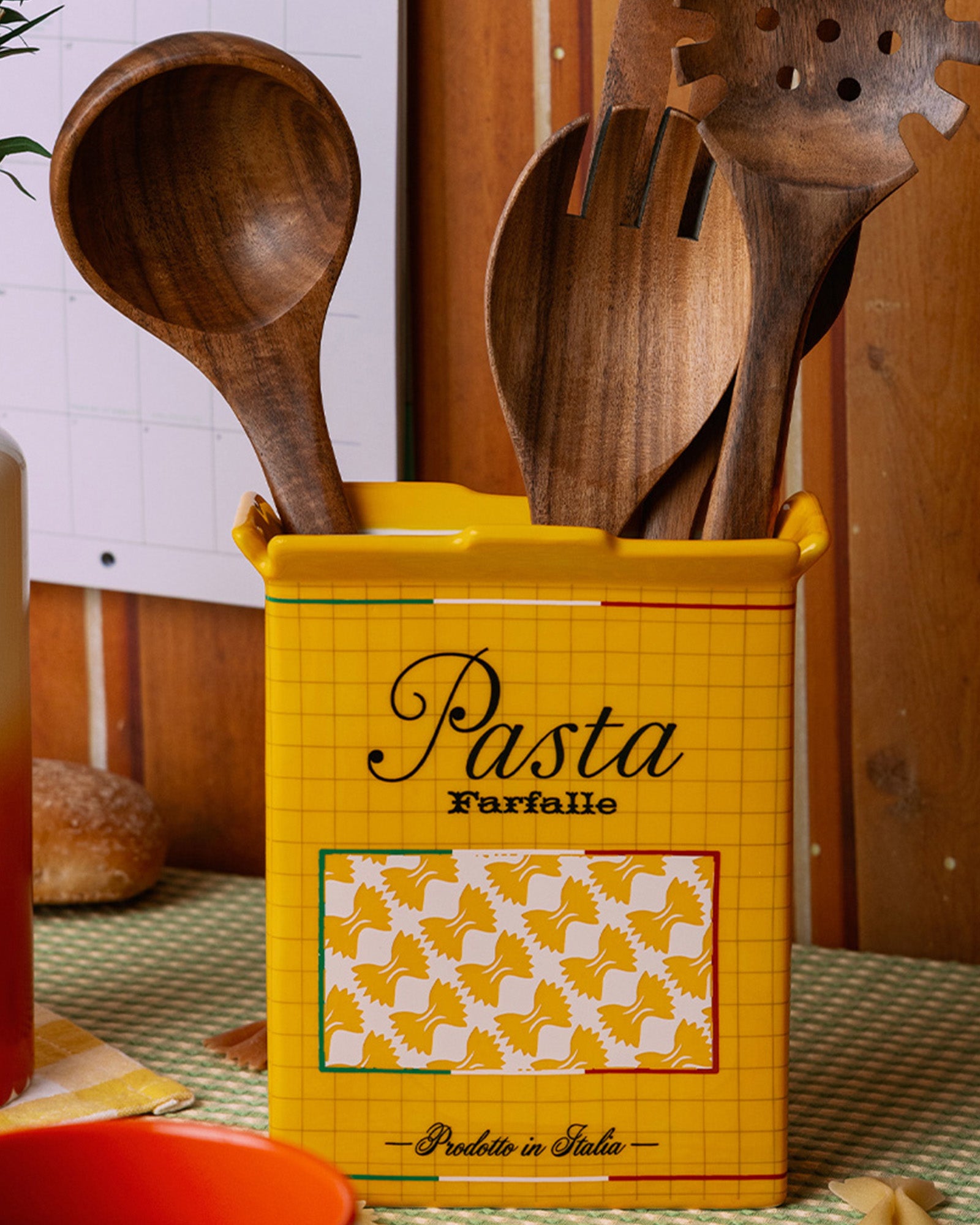 yellow pasta box vase with wooden utensils inside