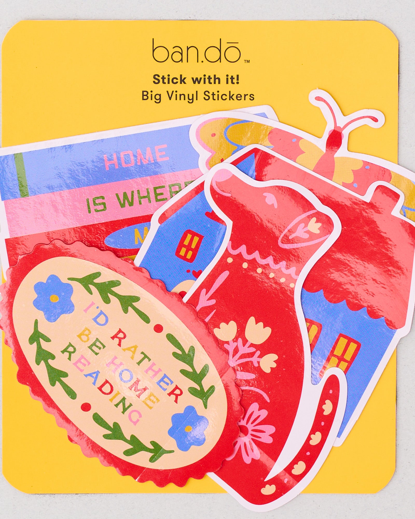Set of colorful vinyl stickers on a yellow doormat with 'bando' branding.