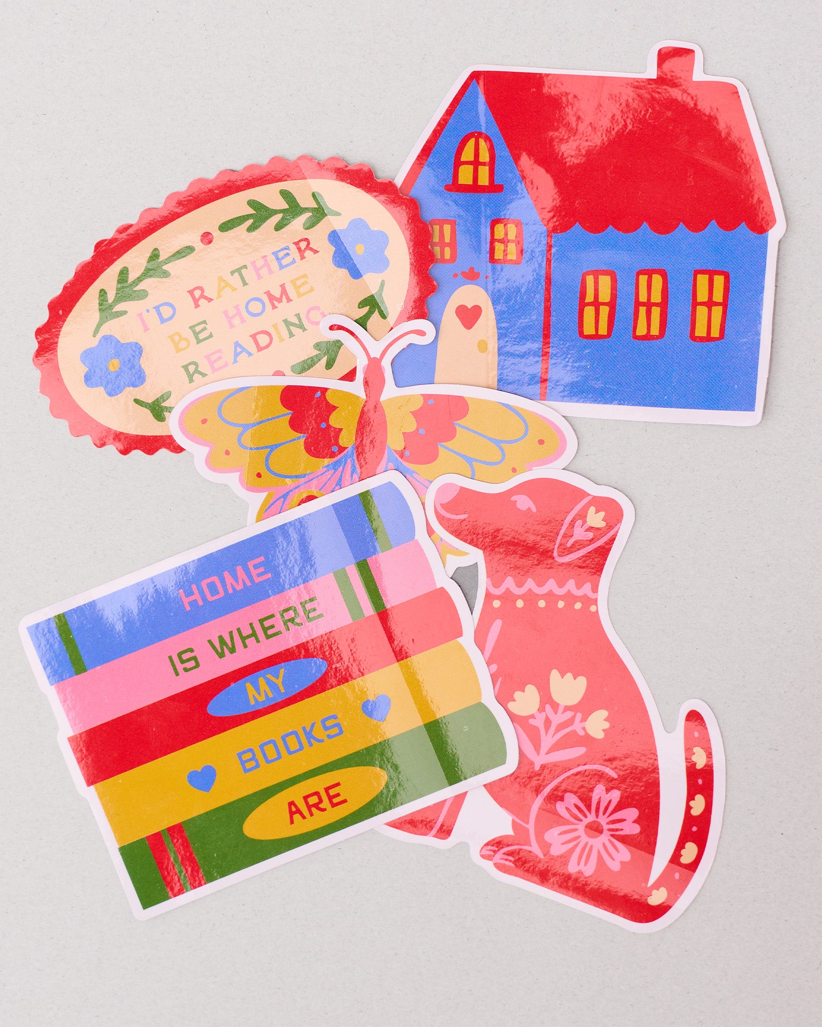Set of colorful stickers with a house, bookshelf, and cat on a light gray background