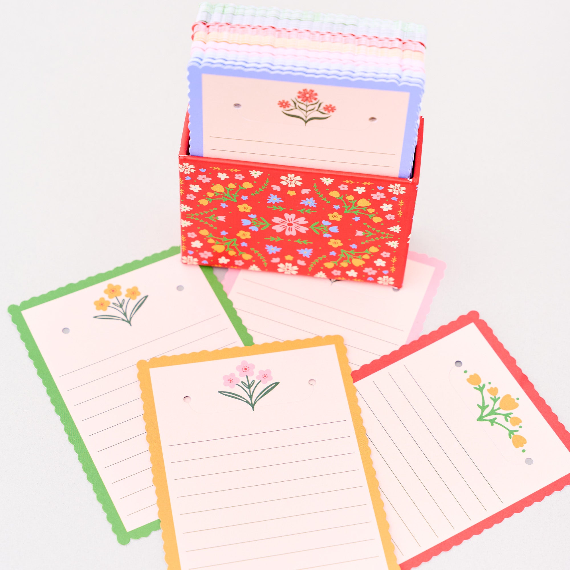 Set of colorful stationery items including cards and a box with floral patterns on a white background.