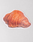 Sticker of a croissant on a light gray background