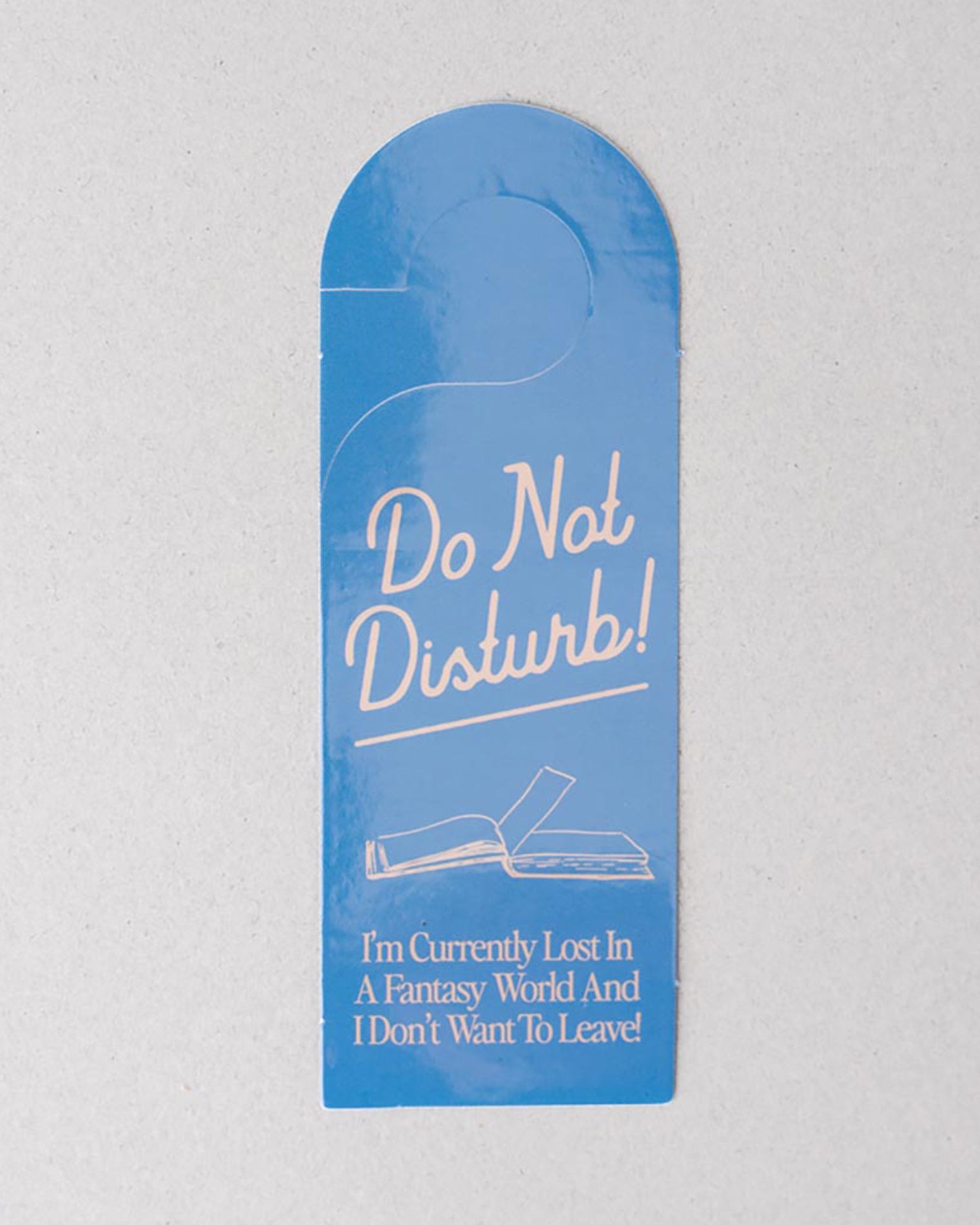 Blue door hanger with 'Do Not Disturb' message on a gray background
