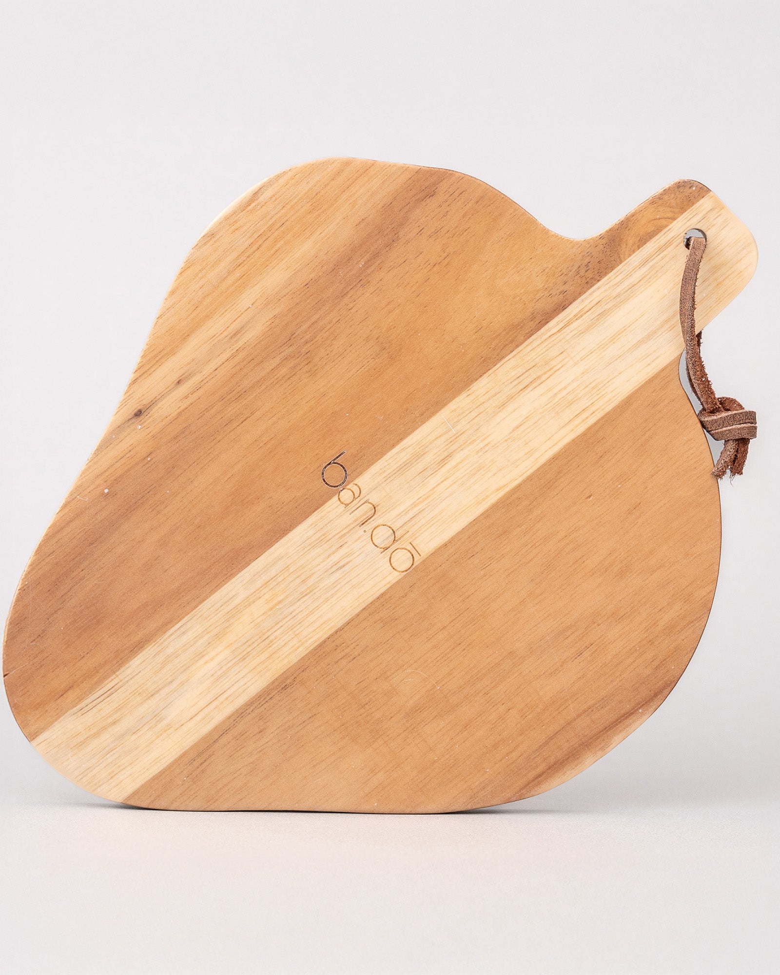 back view of Strawberry-shaped wooden trivet with a green leaf on a light gray background
