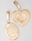Two gold pendants with intricate designs on a light gray background