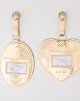 Gold heart and oval luggage tags with name labels on a light gray background