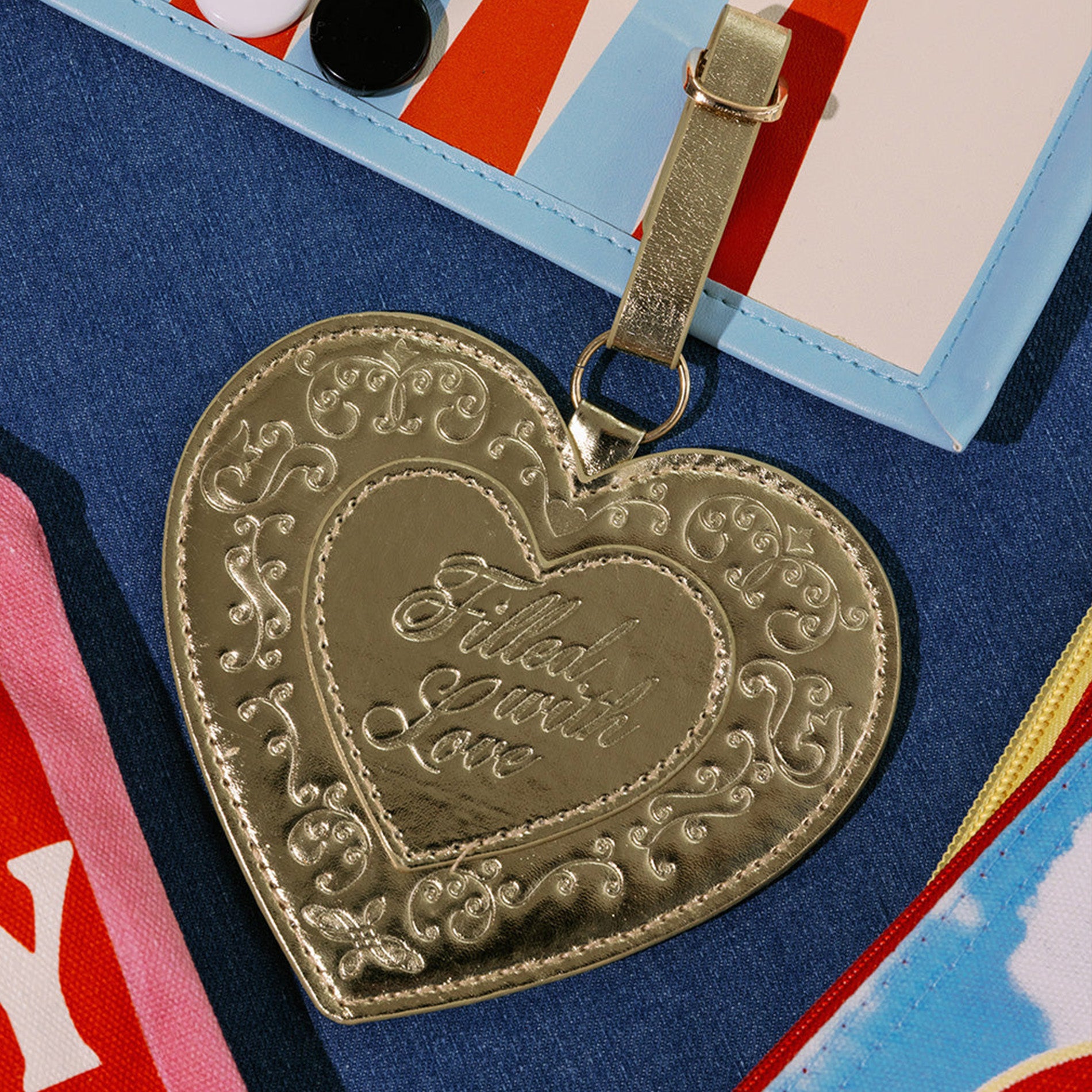 Gold heart-shaped pendant with engraved text on a colorful background