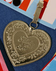 Gold heart-shaped pendant with engraved text on a colorful background