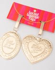 Gold luggage tags with 'Filled with Love' text on a striped bandit packaging background