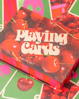 Playing card set with cherry design on a colorful background