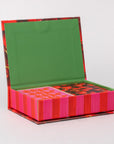 Colorful box with a green lid and pink and red striped base on a white background