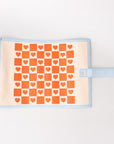 roll up checkers and backgammon with orange heart pattern on a beige background
