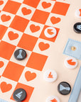 Checkered board with heart patterns and game pieces on a beige background