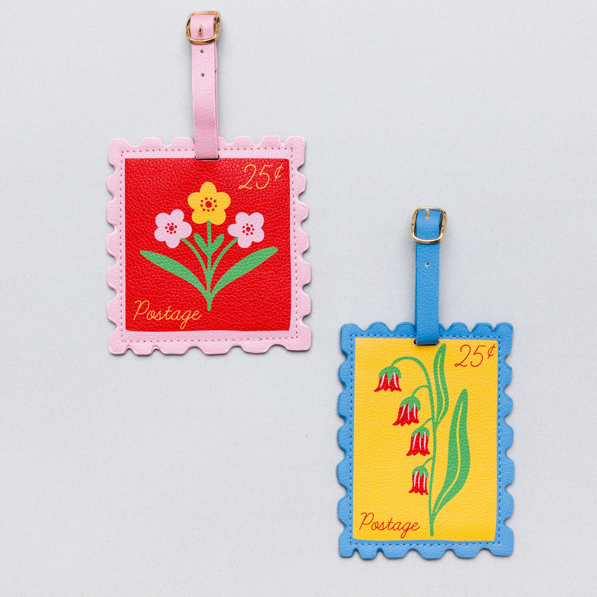 Two vintage-style postage luggage tags on a light gray background. One tag has a pink border, a red center, and pink, yellow, and white flowers with a pink strap and gold buckle.