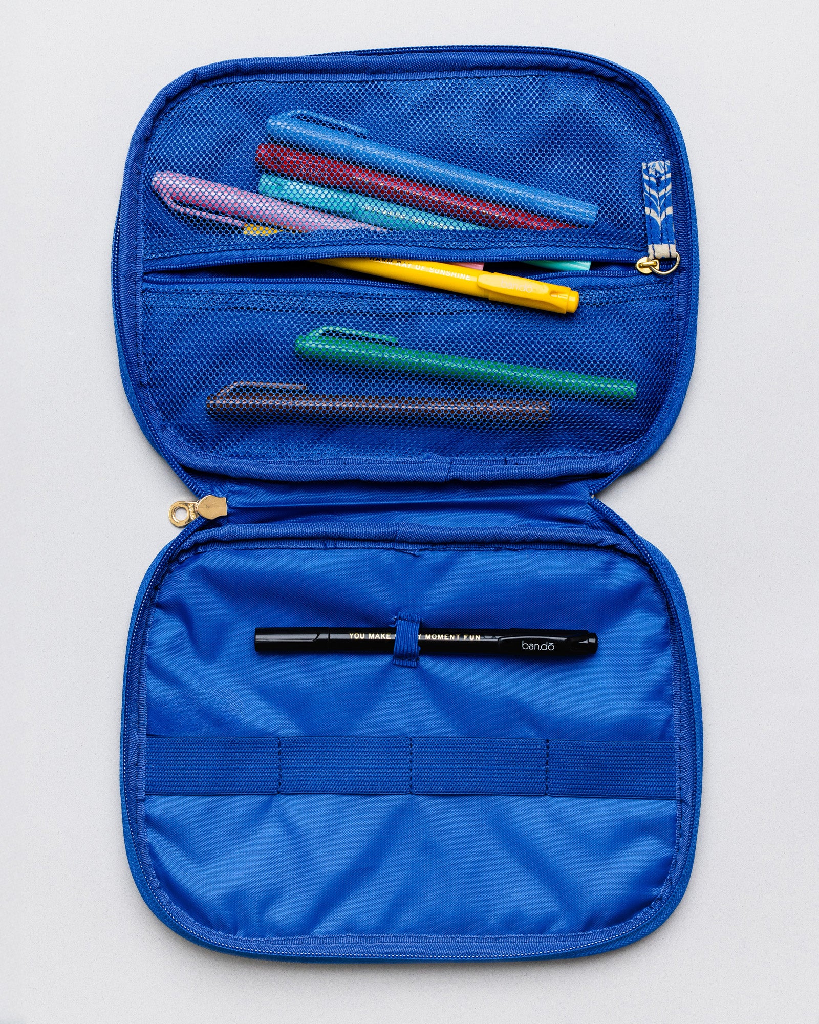 An open blue mesh pen case on a light gray background, showing several colorful pens stored in the upper compartment and a black pen in the lower compartment.