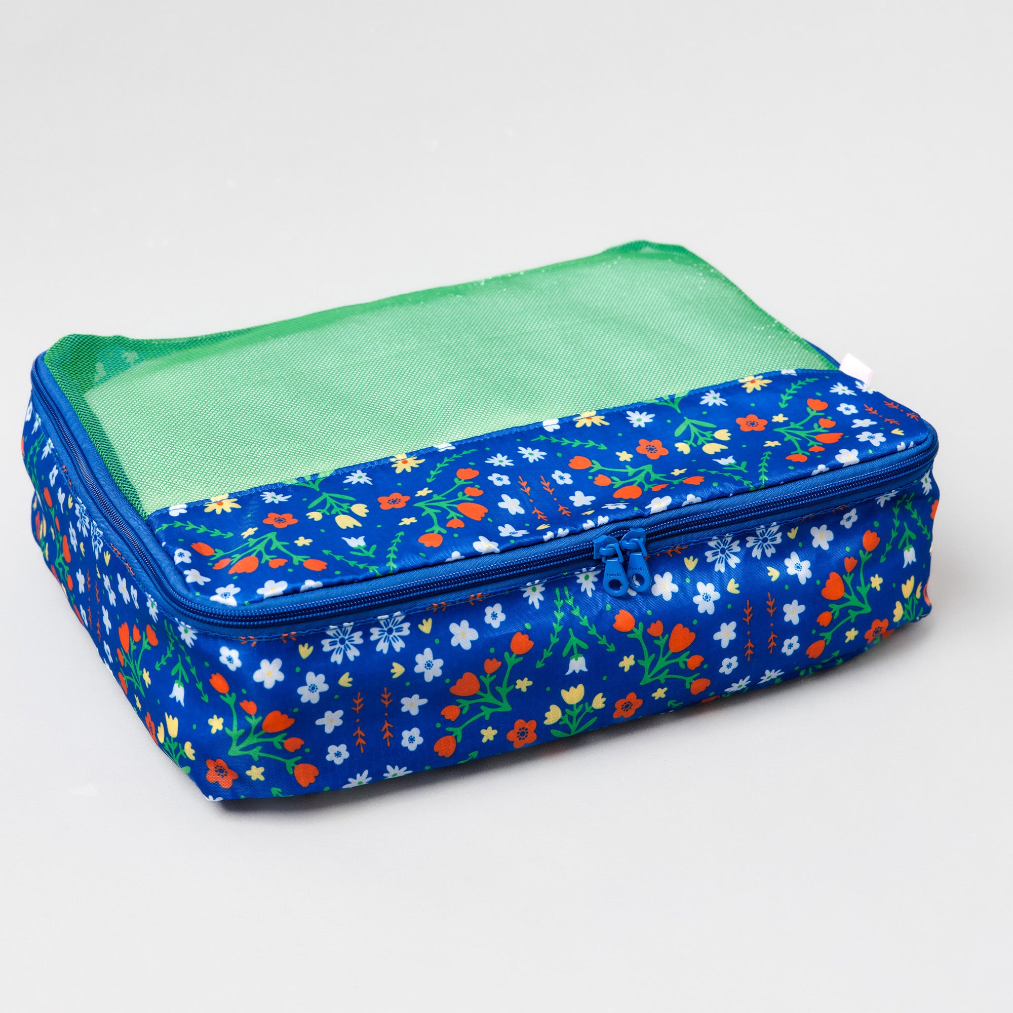 A rectangular zippered travel organizer bag with a blue floral patterned exterior and a green mesh top window, shown on a light gray background.