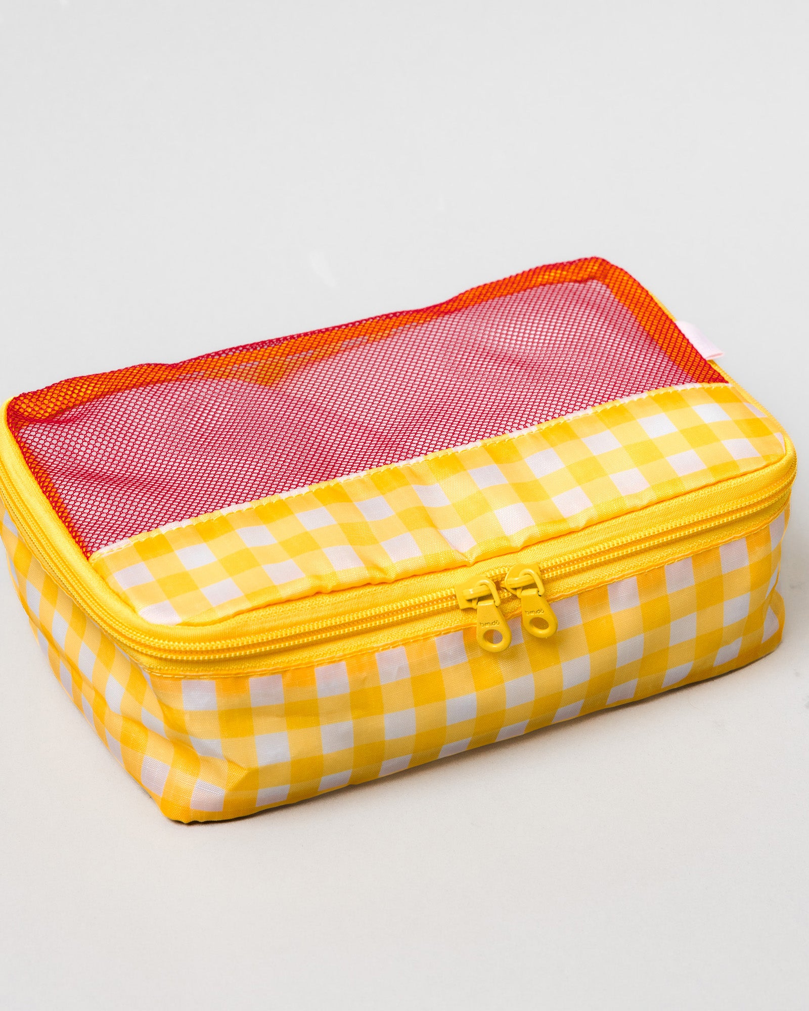 A rectangular zippered travel pouch with a yellow and white gingham pattern, featuring a pink mesh window on the lid and an orange inner lining.