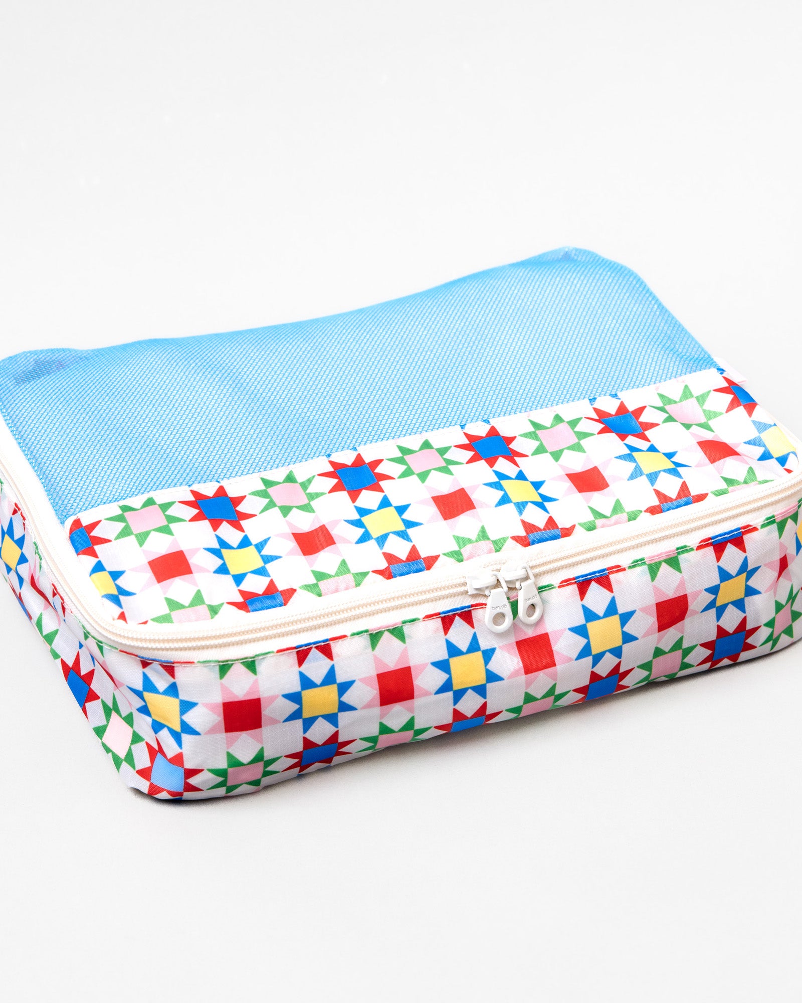 A rectangular zippered travel pouch with a light blue mesh top and a white base printed with a colorful geometric star pattern, shown on a plain white background.