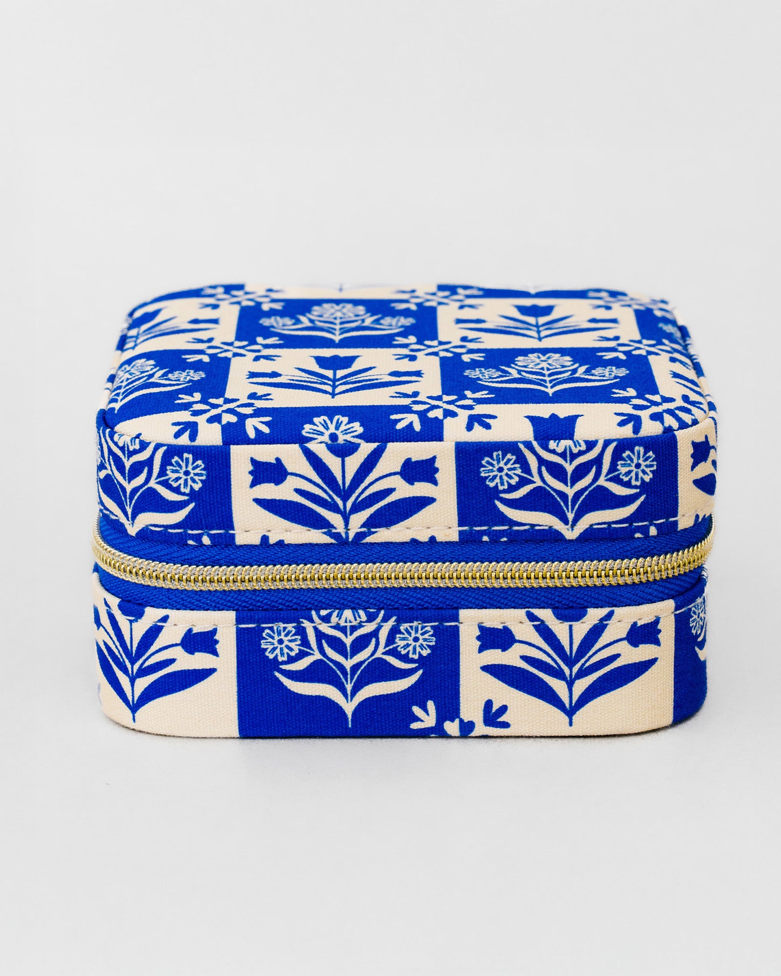 A square zippered storage box with a blue and cream floral block-print pattern, shown on a light gray background.