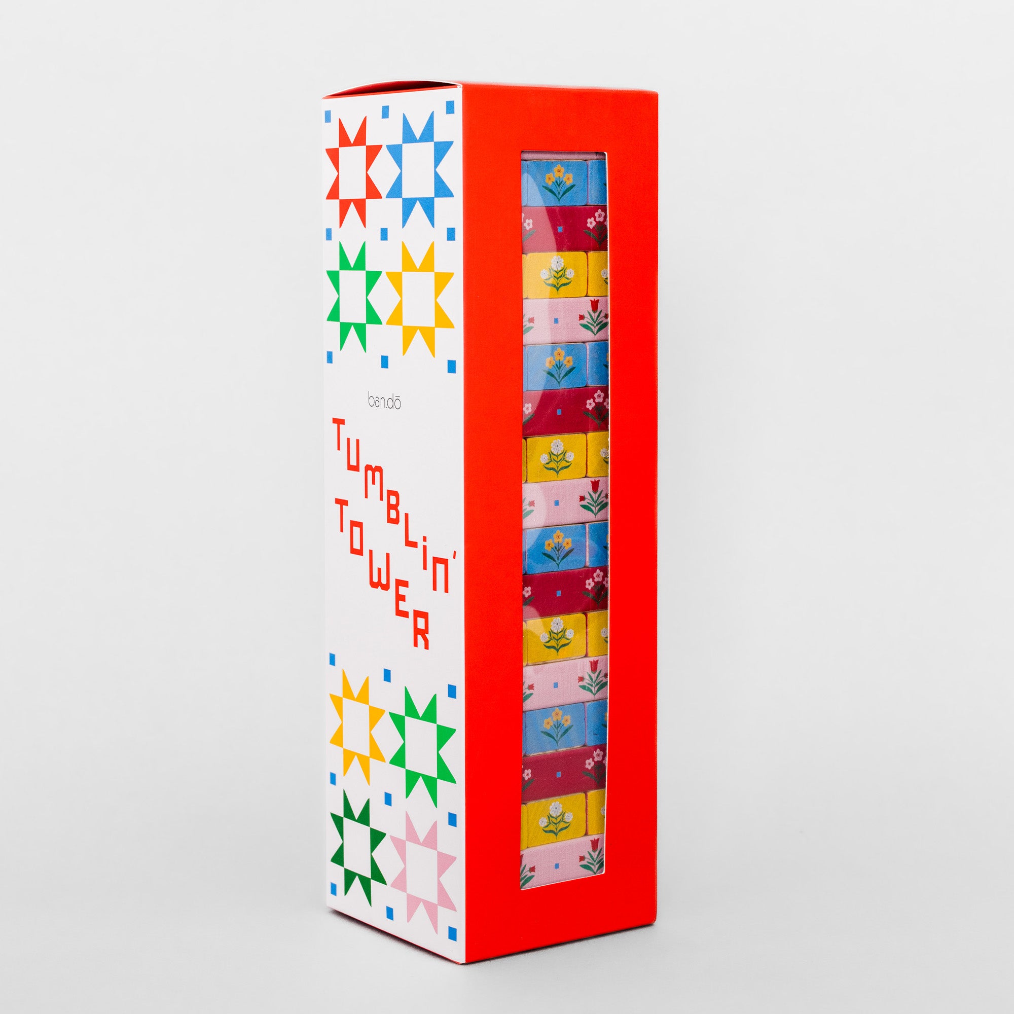 A boxed set of colorful cards in a tall rectangular package with a red side, white front panel, and a clear window showing the stacked card faces. The package text reads 'tumble tower' and 'cards'.