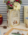 Decorative items including a book-shaped vase with flowers, a mug, and a honey pot against a striped background.