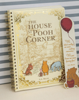 Notebook titled 'The House at Pooh Corner' with a Pooh bear sticker on a striped background