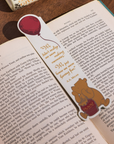 Bookmark with Winnie the Pooh and a balloon on an open book