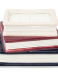 Stack of ceramic books with red, white, and blue stripes on a white background