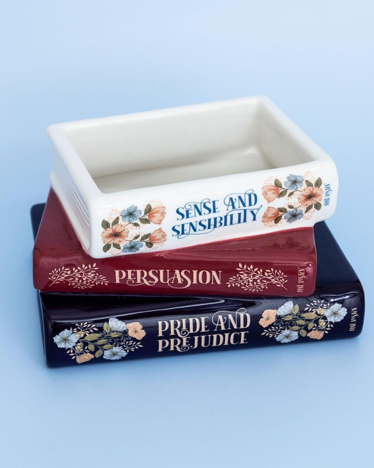 Decorative container with 'Sense and Sensibility', 'Persuasion', and 'Pride and Prejudice' on a blue background