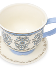Ceramic cup with decorative blue patterns on a matching saucer with text, on a white background