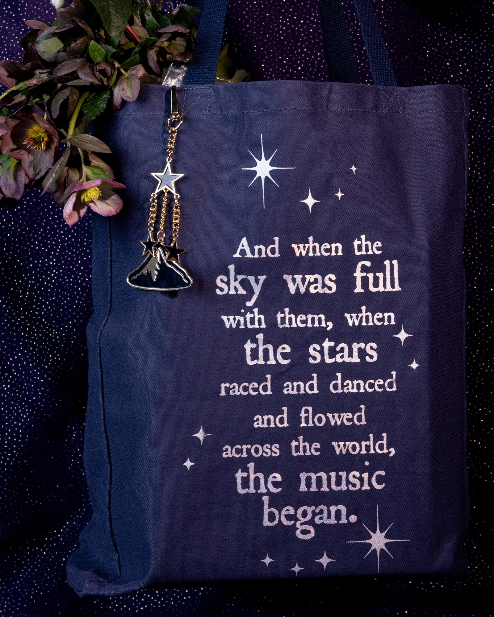 Keychain with mountain and star charms on a navy tote