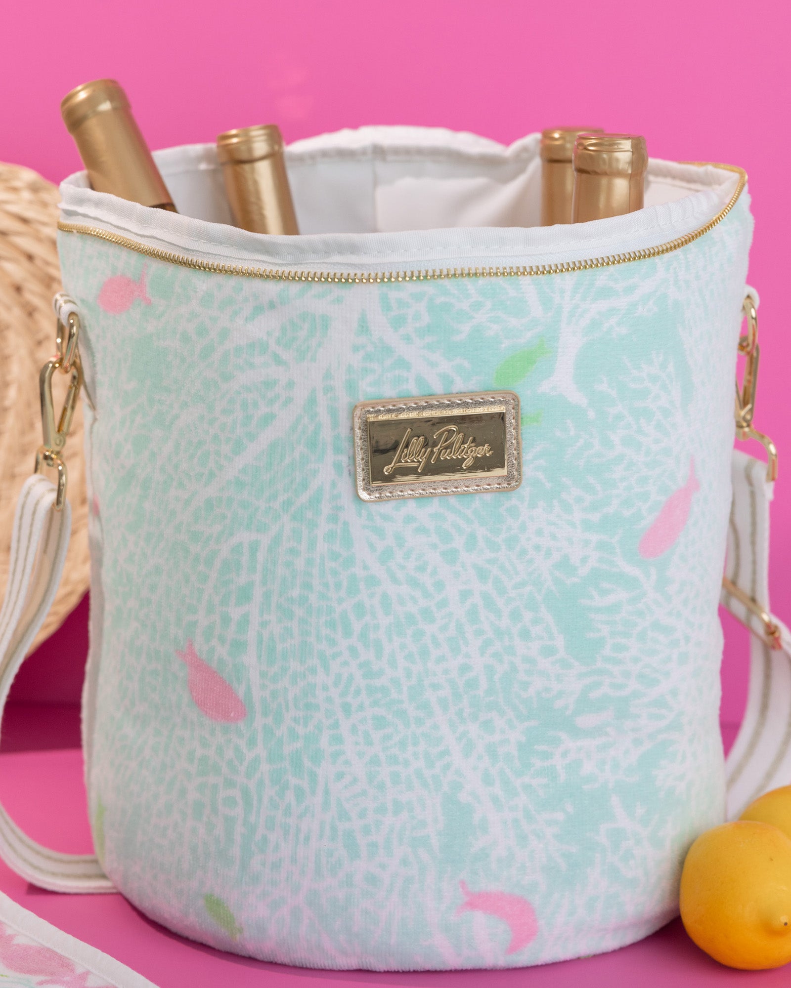 Small cylindrical handbag with floral pattern and gold accents on a white background
