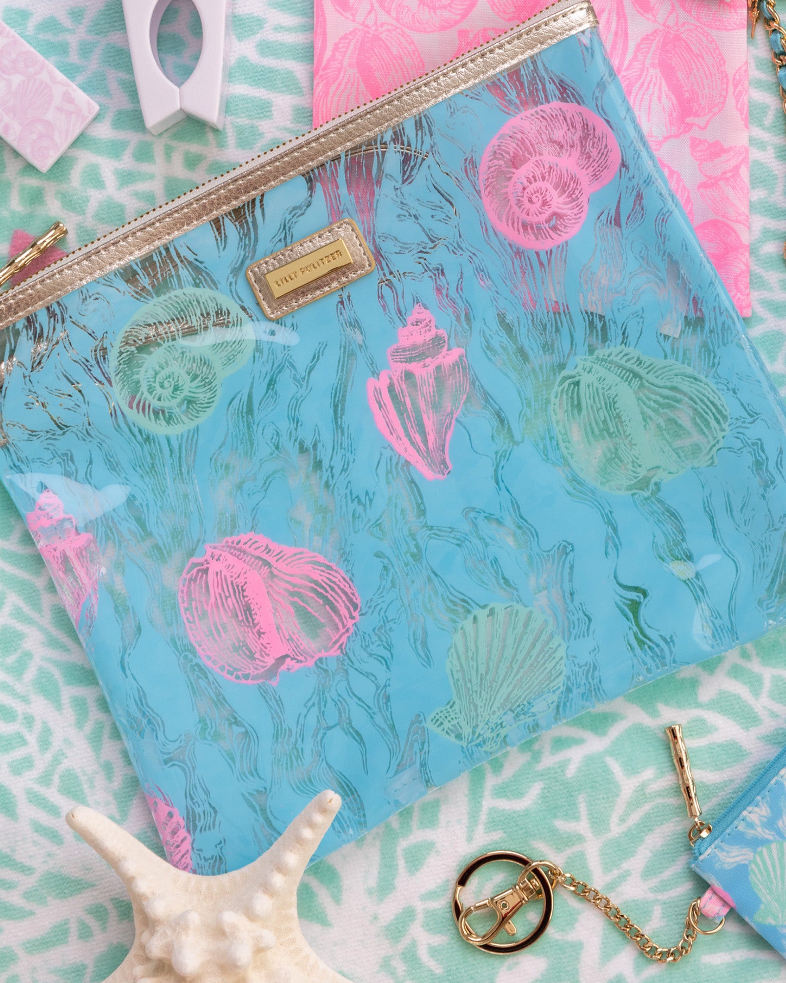 blue pouch with colorful seashell print on a blue beach towel