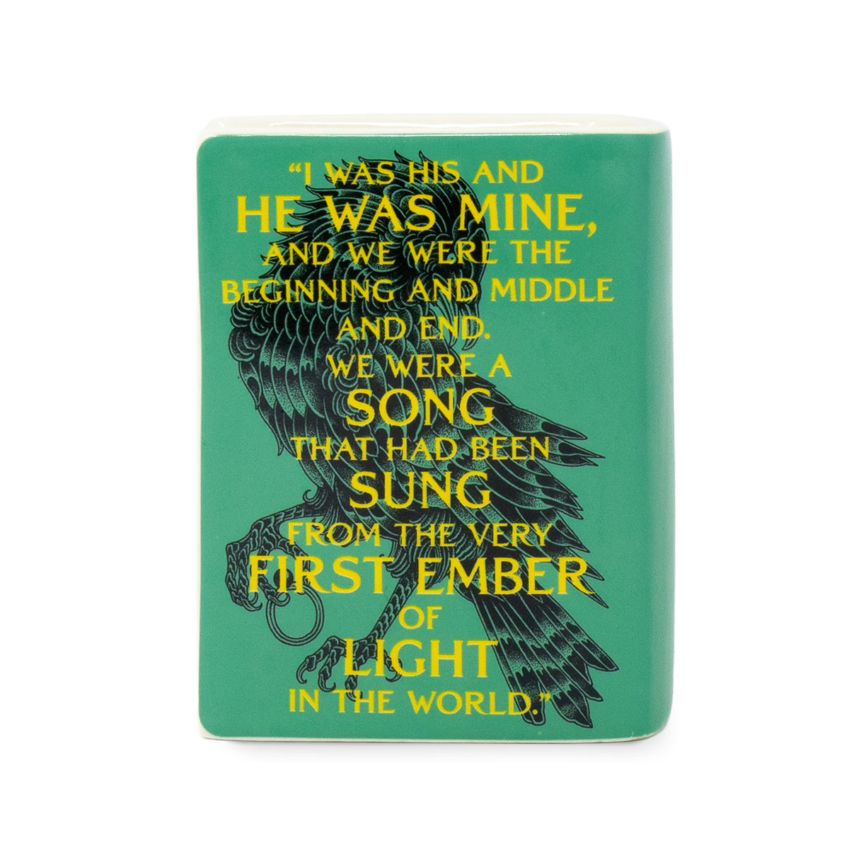 A rectangular teal ceramic candle featuring a black raven illustration