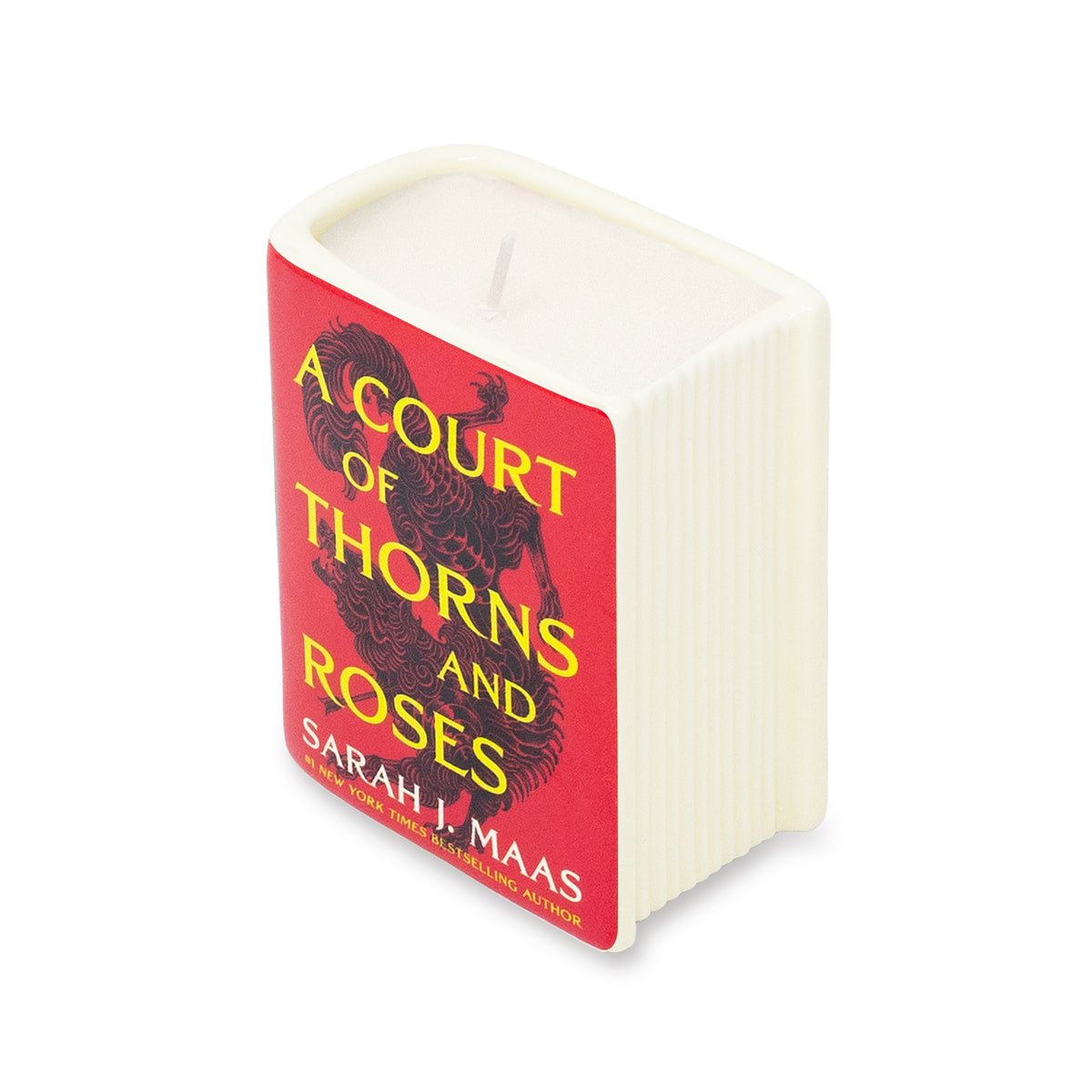 A square-shaped candle designed to look like a hardcover book, featuring an off-white ribbed cover and a red front cover printed with the title 'A Court of Thorns and Roses' in yellow and black, and the author name 'Sarah J. Maas' in white.