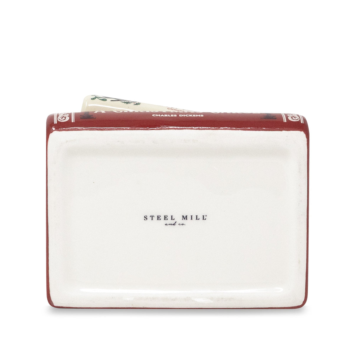 A rectangular ceramic money box designed to look like a vintage book, featuring a white cover with 'STEEL MILL and Co.' printed in black, and a dark red spine with gold decorative details.