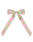 Green and pink patterned bow on a white background