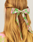 model wearing green hair bow with pink flowers