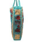 side view of teal beauty and the beast 'book cover' tote bag